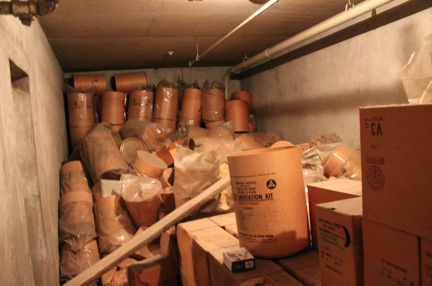 |<image-caption></p>
<p>The view from inside City Hall’s stash of rations and supplies for the aftermath o|The Boston Courant” title=”|<image-caption>
<p>The view from inside City Hall’s stash of rations and supplies for the aftermath o|The Boston Courant” /></div>
<p><!-- END scald=2545 --></div>
</div>
<p>“I’m just not that brave,” she told Metro. “I think, you know, 10 years expired is too long. Fifty years, you’re just taking your life in your hands.”</p>
<p>Boston isn’t alone in squirreling away fallout food, now going ultra-stale and tempting taste-testers, said David Monteyne, a professor at the University of Calgary, who wrote a book on the subject. Many, many buildings have them, the products of the massive federal civil defense program that launched in the 1950s, he said.</p>
<p>Moving them from forgotten basements and storage closets is heavy and inconvenient work, so they tend to stick around, he said.
<p><i><b>RELATED: <a href=