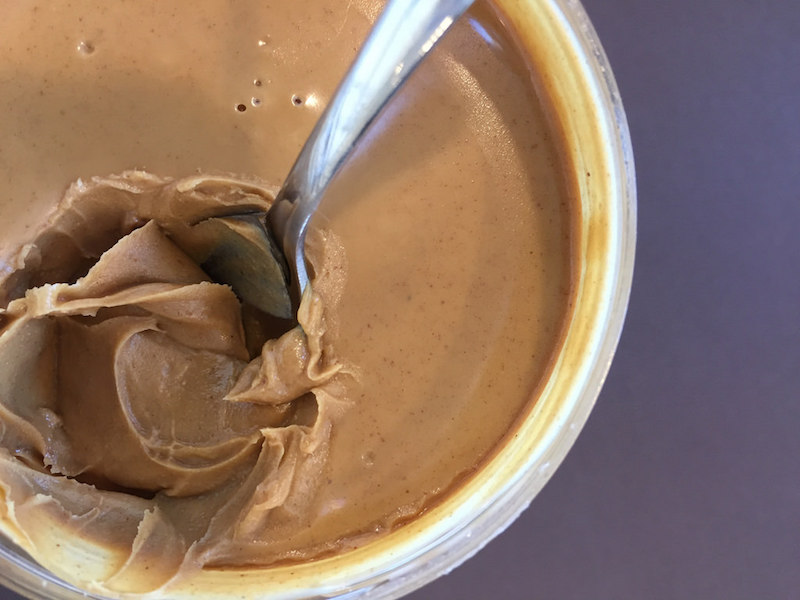 |<image-caption/>|NIAID/Flickr” title=”|<image-caption/>|NIAID/Flickr” /></div>
<p><!-- END scald=3534 --></div>
</div>
<p>A serving of low-fat peanut butter has the same amount of calories as a serving of the regular sticky stuff, which means less of the heart-healthy, monounsaturated type. Some dietary fat is needed to keep you satisfied for longer, keep your hunger hormones in check and to aid in the absorption of some vitamins.</p>
<p>Low-fat peanut butters contain more sugar and more sodium then their full-bodied cousins, which can make your sugar intake jump from 1 gram per serving to 4 grams and sodium spike to 220 milligrams from 105 milligrams.</p>
<p>Before you turn the jar to peek at the back label, look at the front. Is this a butter or a spread? PB spreads only have to contain 90 percent peanuts. Reduced-fat spreads get away with 60 percent.</p>
<p>Ideally, the nut butter in your pantry or fridge should have one ingredient: nuts, whether that’s our legume friend, the peanut, or almonds or cashews. Some natural nut butters also contain salt. If you have to decide between hydrogenated fats and sodium, go with the shorter ingredient list.</p>
<p>If you’re looking for peanut-y flavor with 90 percent less fat, PB2 is a dehydrated version of peanut butter. The peanut oil is removed, which makes it less than ideal for spreading, but a killer choice for smoothies, cookies, Thai dishes and other recipes.</p>
<p>And OMG, hi, <a href=